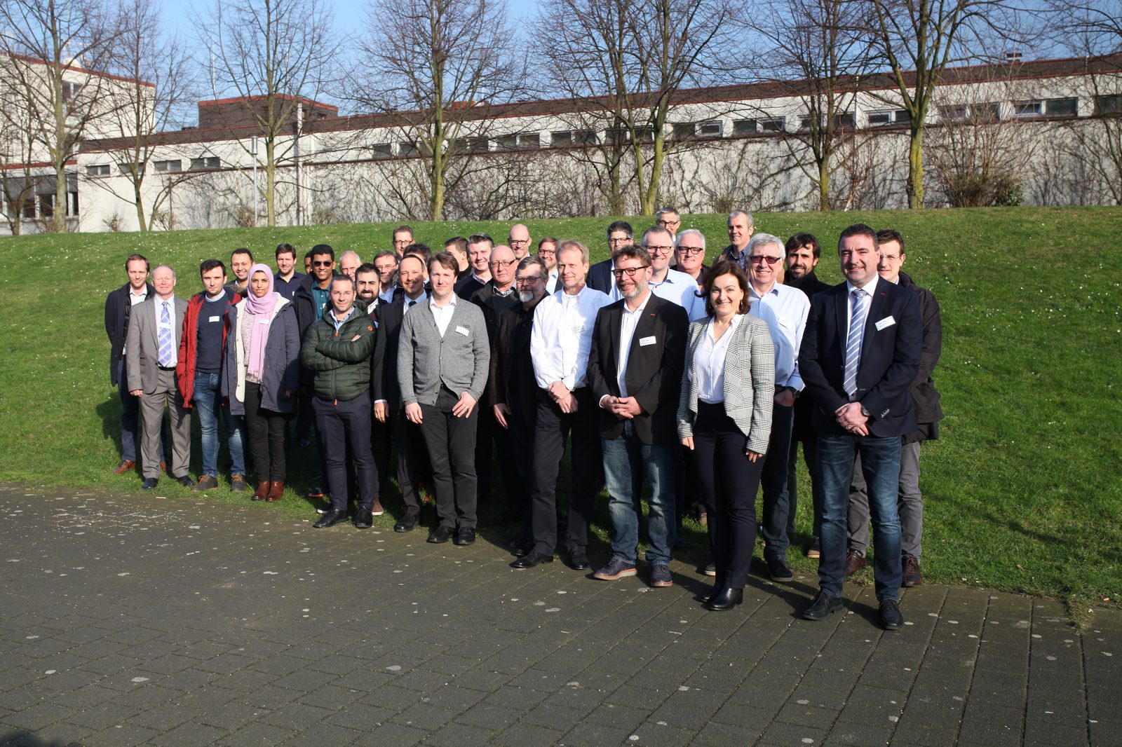 Group photo of around 35 workshop participants outdoors on a sunny winter day
