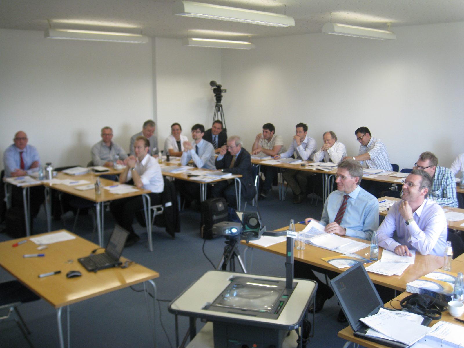 Workshop participants at tables, trainer presenting at the screen